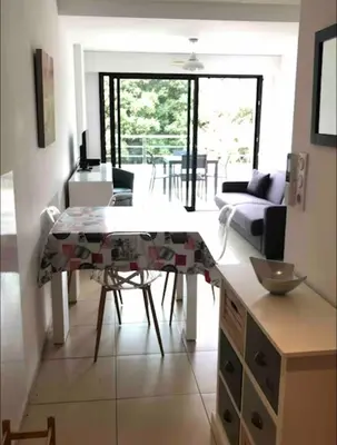 a kitchen and living room with a table and chairs at propriano pieds dans l eau in Propriano