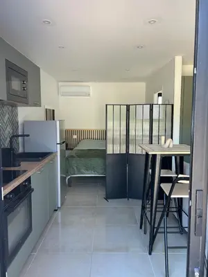a kitchen with a table and a refrigerator at Le cocon de Malo in Lecci