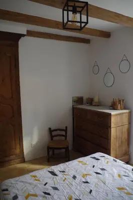 a bedroom with a bed and a dresser and a chair at Typical Corsican apartment in Cervione