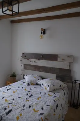 a bedroom with a bed with a wooden headboard at Typical Corsican apartment in Cervione