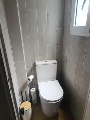 a small bathroom with a toilet and a window at Typical Corsican apartment in Cervione