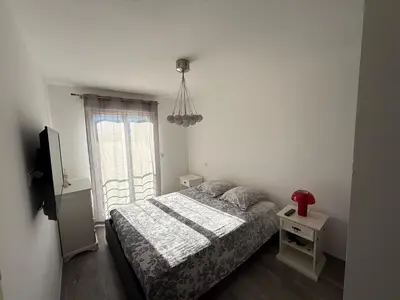 a small bedroom with a bed and a window at Confortable T3 10 min plage in Lucciana