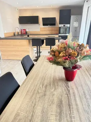 a vase of flowers on a table in a kitchen at Confortable T3 10 min plage in Lucciana