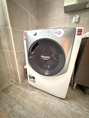 a washing machine in the corner of a bathroom at Confortable T3 10 min plage in Lucciana