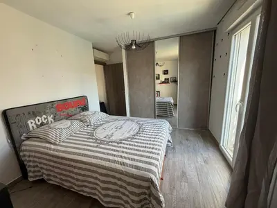 a bedroom with a bed with a striped comforter at Confortable T3 10 min plage in Lucciana