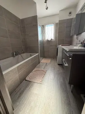 a bathroom with a tub and a sink at Confortable T3 10 min plage in Lucciana