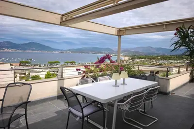 a bathtub on a balcony with a view of the ocean at Apartment with terrace close to the beach in Grosseto-Prugna