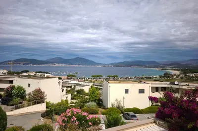 a patio with a couch and chairs on a balcony at Apartment with terrace close to the beach in Grosseto-Prugna