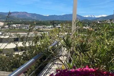 a balcony with flowers and mountains in the background at Apartment with terrace close to the beach in Grosseto-Prugna