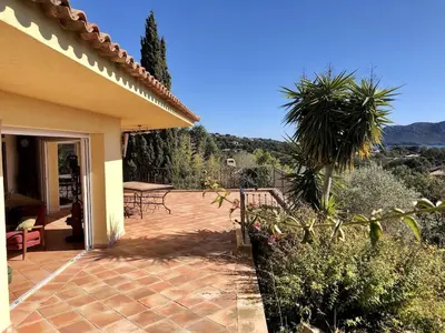 a house with a patio with a table and chairs at CASA 'LLU PILOTA - Grand appartement dans villa plein sud vue mer - Large apartment in a south-facing villa with sea view in Porto-Vecchio