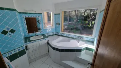 a bathroom with a tub and a sink and a window at CASA 'LLU PILOTA - Grand appartement dans villa plein sud vue mer - Large apartment in a south-facing villa with sea view in Porto-Vecchio