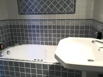 a bathroom with a white tub and a sink at CASA 'LLU PILOTA - Grand appartement dans villa plein sud vue mer - Large apartment in a south-facing villa with sea view in Porto-Vecchio