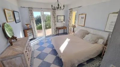 a bedroom with a large bed and a window at CASA 'LLU PILOTA - Grand appartement dans villa plein sud vue mer - Large apartment in a south-facing villa with sea view in Porto-Vecchio