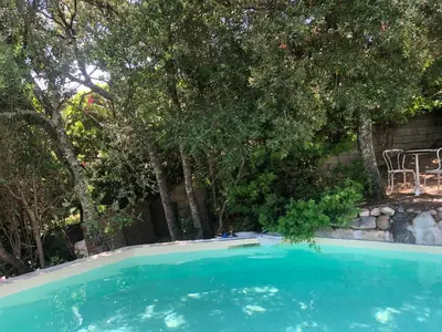 a swimming pool in a yard with trees at CASA 'LLU PILOTA - Grand appartement dans villa plein sud vue mer - Large apartment in a south-facing villa with sea view in Porto-Vecchio