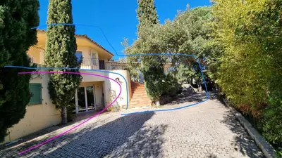 a street with trees and a house with a ribbon at CASA 'LLU PILOTA - Grand appartement dans villa plein sud vue mer - Large apartment in a south-facing villa with sea view in Porto-Vecchio
