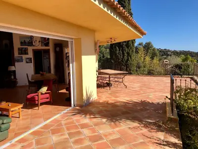 an open door to a patio with a table at CASA 'LLU PILOTA - Grand appartement dans villa plein sud vue mer - Large apartment in a south-facing villa with sea view in Porto-Vecchio