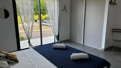 two towels sitting on a bed in a room with a window at Domaine LOADANA in Sainte-Lucie de Porto-Vecchio