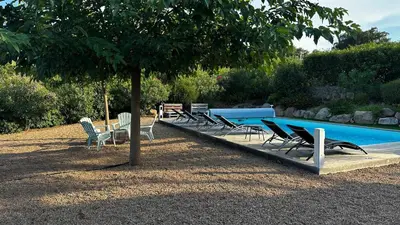 a group of chairs sitting next to a swimming pool at Domaine LOADANA in Sainte-Lucie de Porto-Vecchio