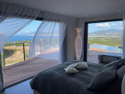 a bedroom with a bed with a view of the ocean at Villa Clémentines Porticcio in Grosseto-Prugna