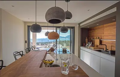 a kitchen with a long wooden table in a room at Villa Clémentines Porticcio in Grosseto-Prugna
