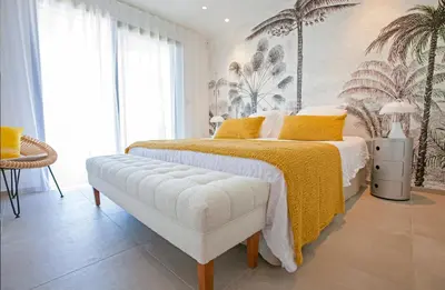 a bedroom with a large bed with a yellow blanket at Villa Clémentines Porticcio in Grosseto-Prugna
