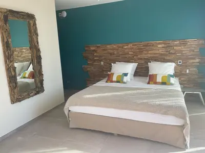 a bedroom with a large bed and a mirror at Villa Clémentines Porticcio in Grosseto-Prugna
