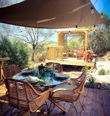a table with chairs and an umbrella on a deck at Glamping luxe entre mer et maquis in Ajaccio