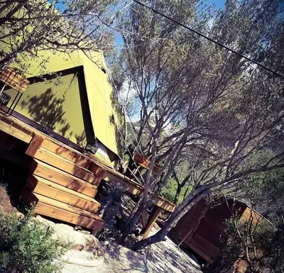 a yellow bulldozer is sitting in the woods at Glamping luxe entre mer et maquis in Ajaccio