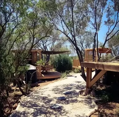 a backyard with a tree house and a deck at Glamping luxe entre mer et maquis in Ajaccio