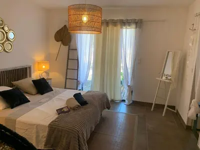 a bedroom with a large bed and a large window at Villa Amacali vue mer piscine chauffée climatisée in Sainte-Lucie de Porto-Vecchio