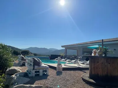 a swimming pool with lounge chairs next to a house at Villa Amacali vue mer piscine chauffée climatisée in Sainte-Lucie de Porto-Vecchio