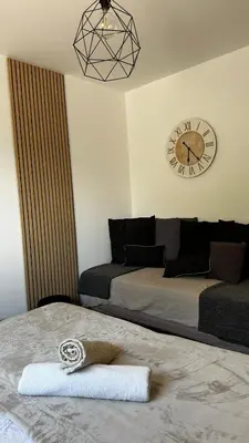 a bedroom with two beds and a clock on the wall at Villa Amacali vue mer piscine chauffée climatisée in Sainte-Lucie de Porto-Vecchio