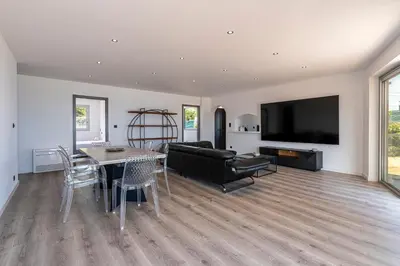 a living room with a table and a couch and a television at Le Roc - 1er étage - Splendide Vue Mer in Coti-Chiavari
