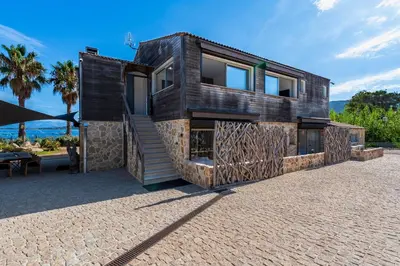 a wooden house with a staircase and a patio at Le Roc - 1er étage - Splendide Vue Mer in Coti-Chiavari