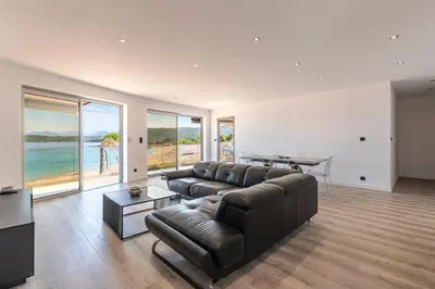 a living room with a leather couch and a table at Le Roc - 1er étage - Splendide Vue Mer in Coti-Chiavari