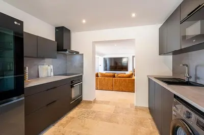 a kitchen with stainless steel appliances and a living room at Le Roc - RDC - Splendide Vue Mer in Coti-Chiavari