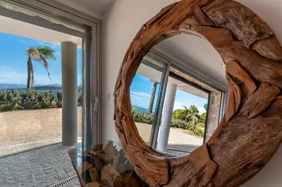 a large wooden mirror in front of a window at Le Roc - RDC - Splendide Vue Mer in Coti-Chiavari