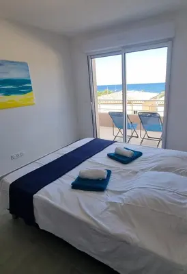 a bedroom with a large bed with blue towels on it at Appartement Carpe diem vue mer plage à pied in Conca