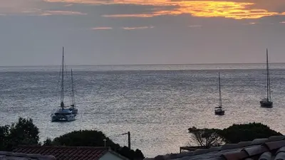 a group of boats in the water at sunset at Appartement Carpe diem vue mer plage à pied in Conca