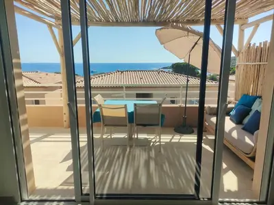 a view of a patio with a table and an umbrella at Appartement Carpe diem vue mer plage à pied in Conca
