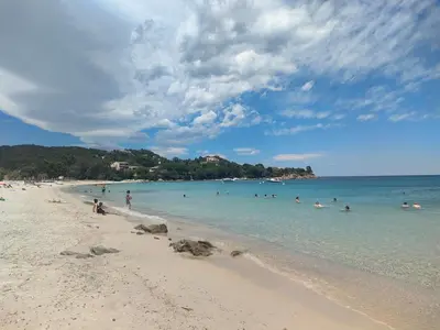a group of people in the water at a beach at Appartement Carpe diem vue mer plage à pied in Conca