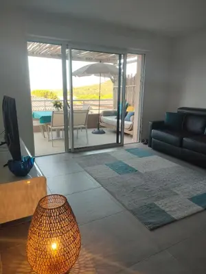 a living room with a couch and a table at Appartement Carpe diem vue mer plage à pied in Conca