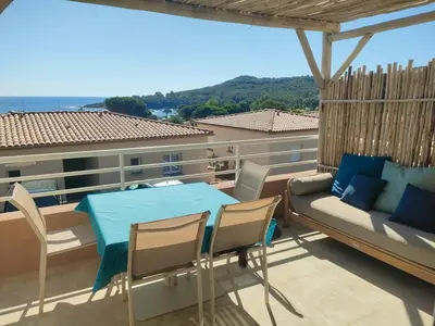 a balcony with a couch and a table and chairs at Appartement Carpe diem vue mer plage à pied in Conca