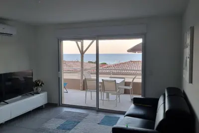 a living room with a couch and a view of the ocean at Appartement Carpe diem vue mer plage à pied in Conca