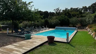 a swimming pool in a yard with chairs around it at Villa Serenita vue mer in Sainte-Lucie de Porto-Vecchio