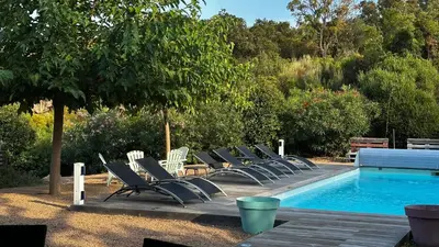 a row of lounge chairs next to a swimming pool at Villa Serenita vue mer in Sainte-Lucie de Porto-Vecchio