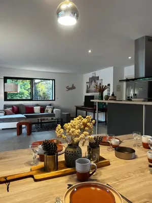 a kitchen and living room with a wooden table at Villa Serenita vue mer in Sainte-Lucie de Porto-Vecchio