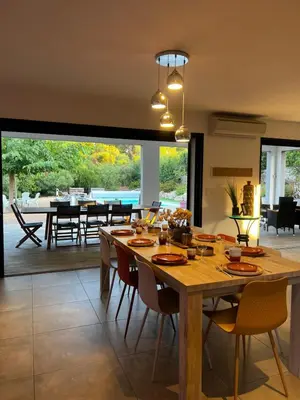 a dining room with a large wooden table and chairs at Villa Serenita vue mer in Sainte-Lucie de Porto-Vecchio