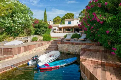 a boat in the water in front of a house at Villa Sempietru, 8 pers, lagon & plage à pied in Lecci