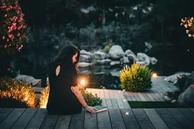 a woman in a black dress is holding a book at Villa Sempietru, 8 pers, lagon & plage à pied in Lecci